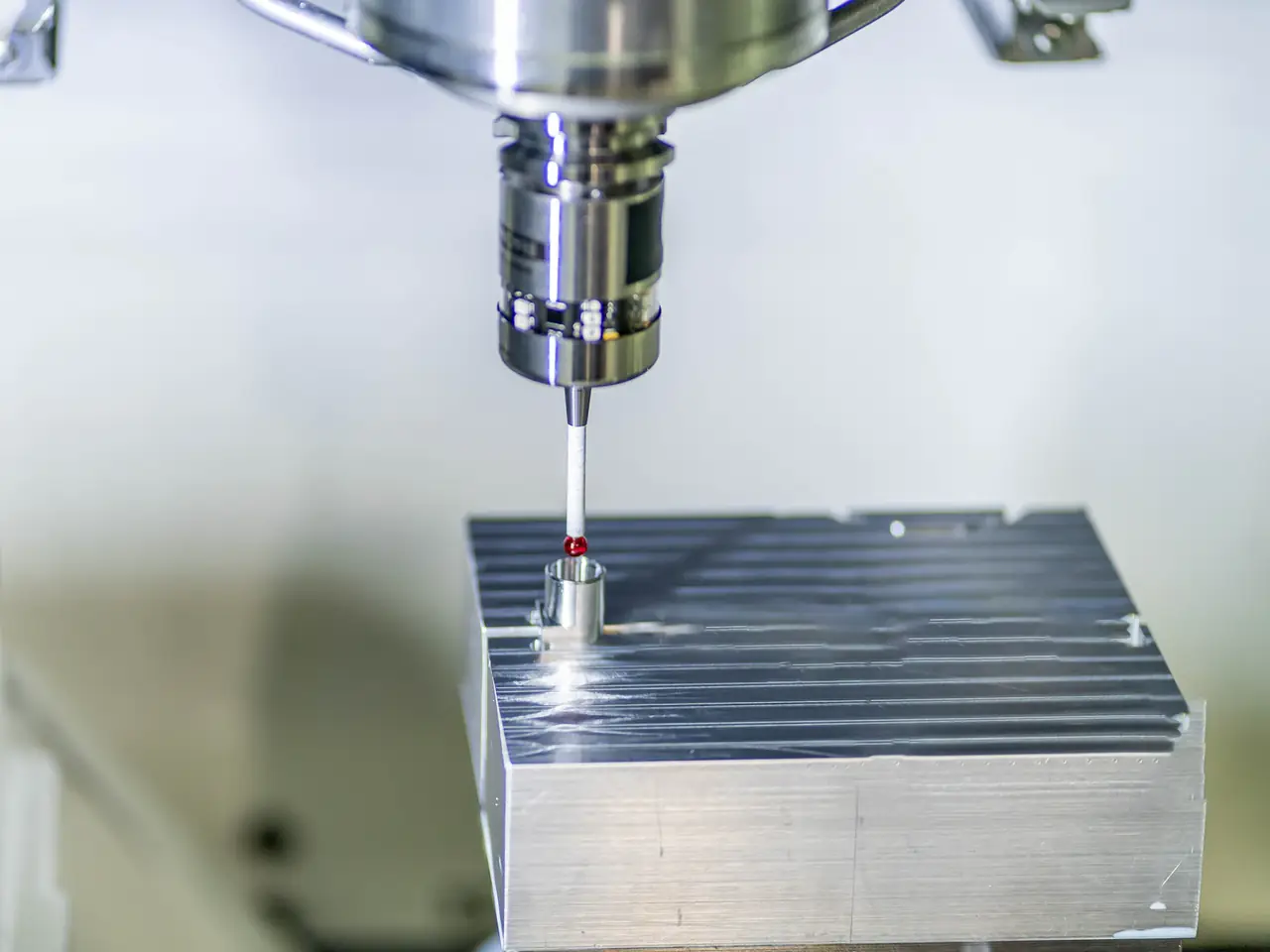 Messtaster einer CNC-Maschine an einem gefrästen Aluminiumwerkstück