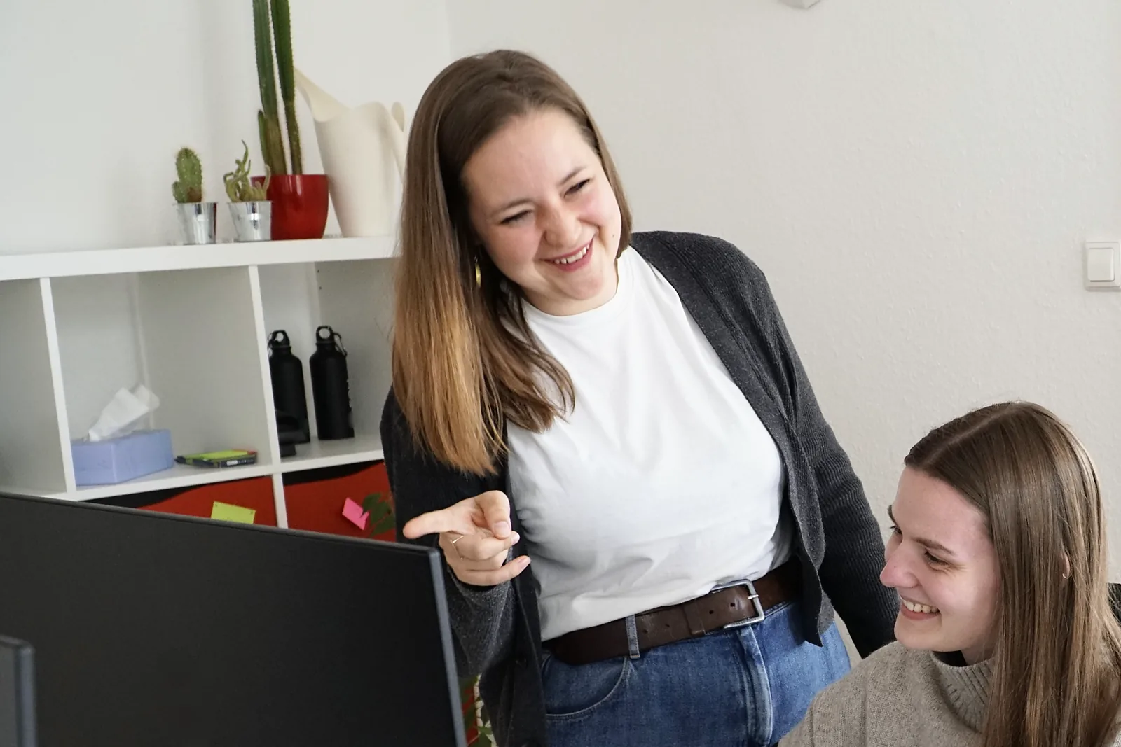 Roxeanne Rieck und Sharia Gageler aus dem EOM-Team im Gespräch am Bildschirm, Roxeanne zeigt auf den Monitor