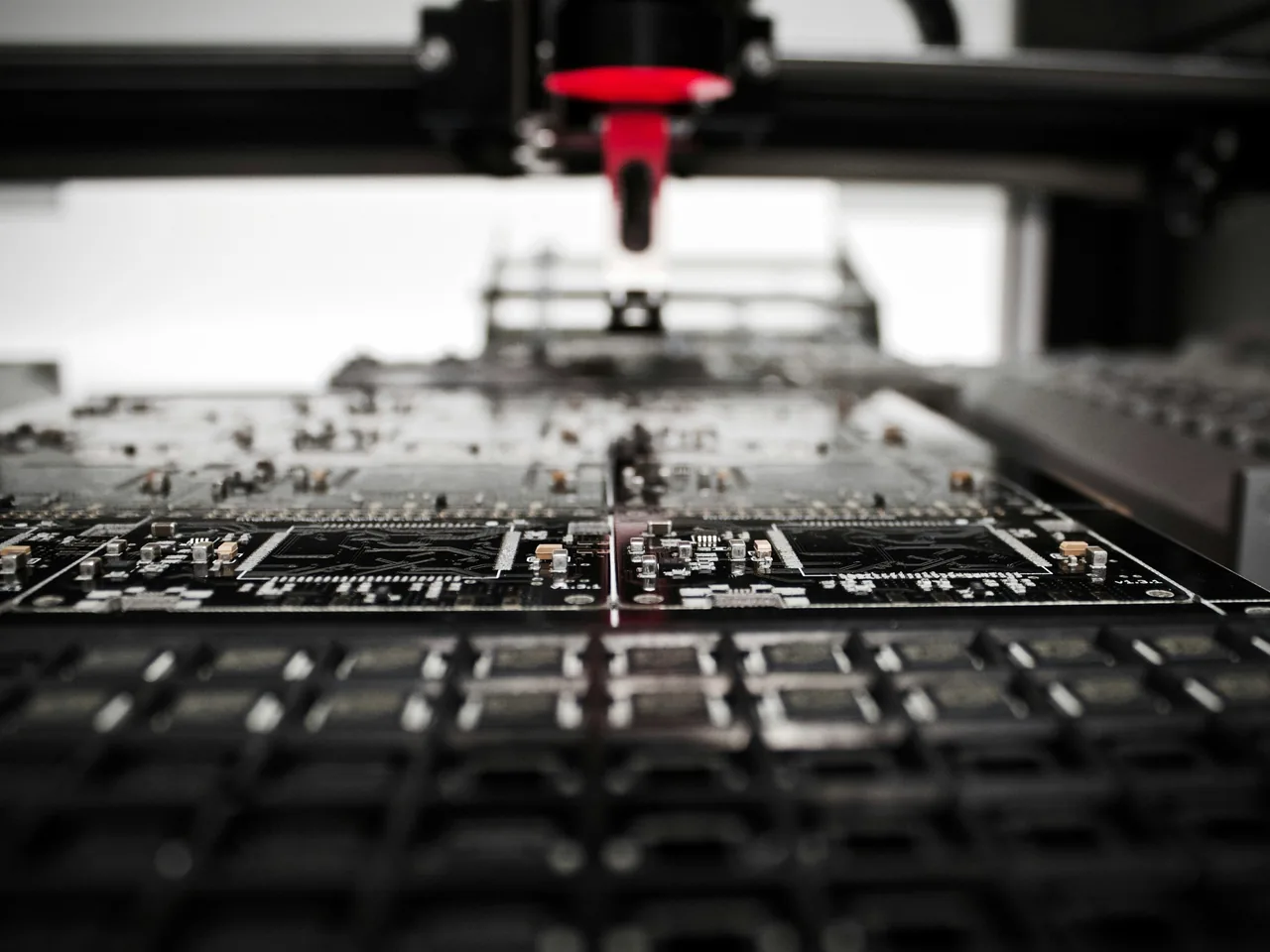 Maschinenkopf über Leiterplatten mit elektronischen Bauteilen in einer Fertigungsanlage