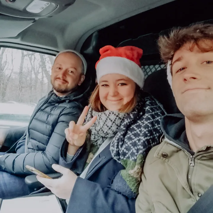 Ernest Mavriqi am Steuer des Transporters, daneben zwei aus dem Team mit Weihnachtsmütze, unterwegs zu den Einrichtungen im Dezember 2019